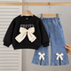 Tenue élégante pour fille avec une touche moderne - haut noir avec nœud papillon élégant et jean plissé attrayant