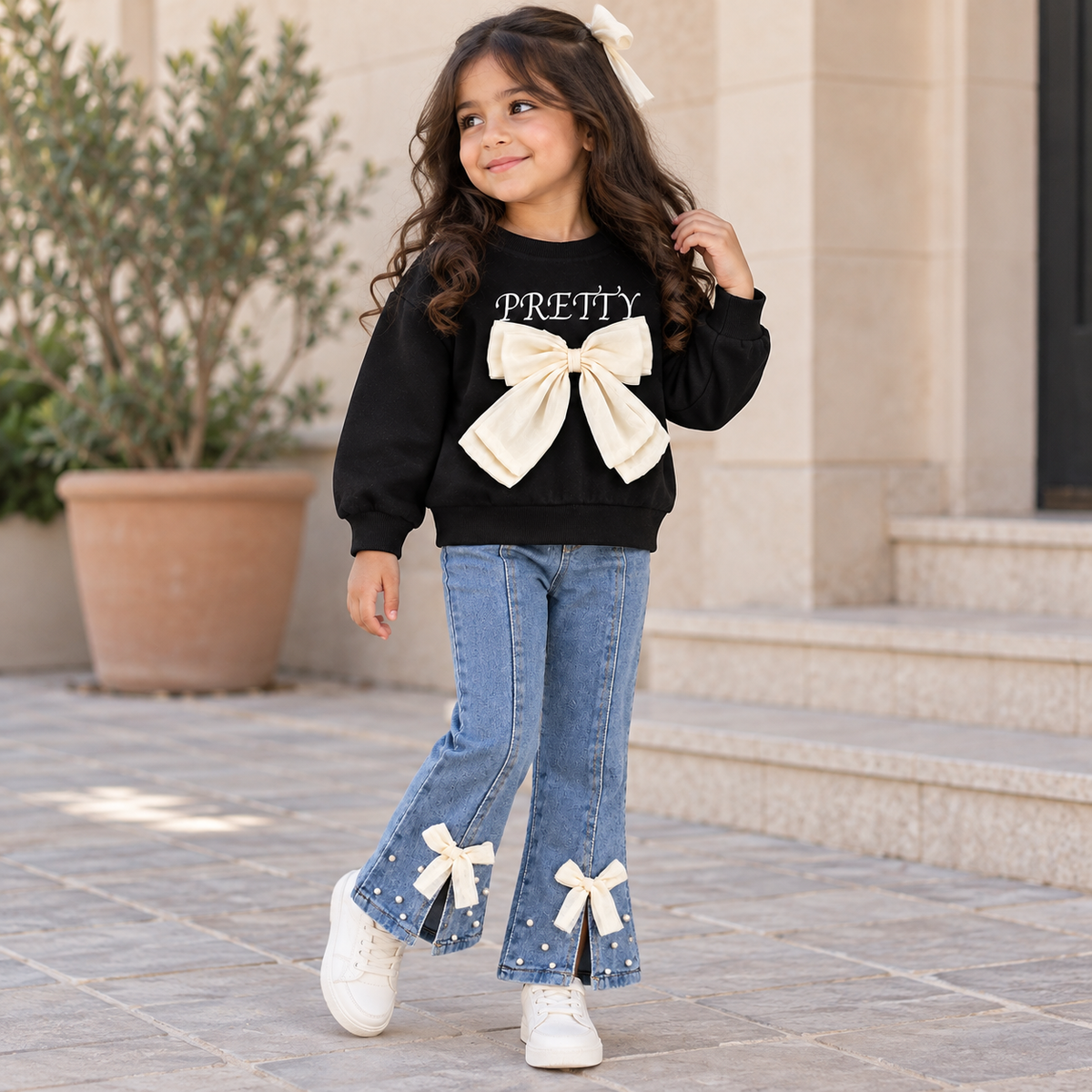 Tenue élégante pour fille avec une touche moderne - haut noir avec nœud papillon élégant et jean plissé attrayant